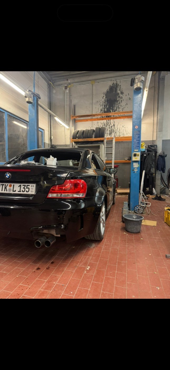 Heckansicht des BMW 1er auf der Hebebühne in der Werkstatt